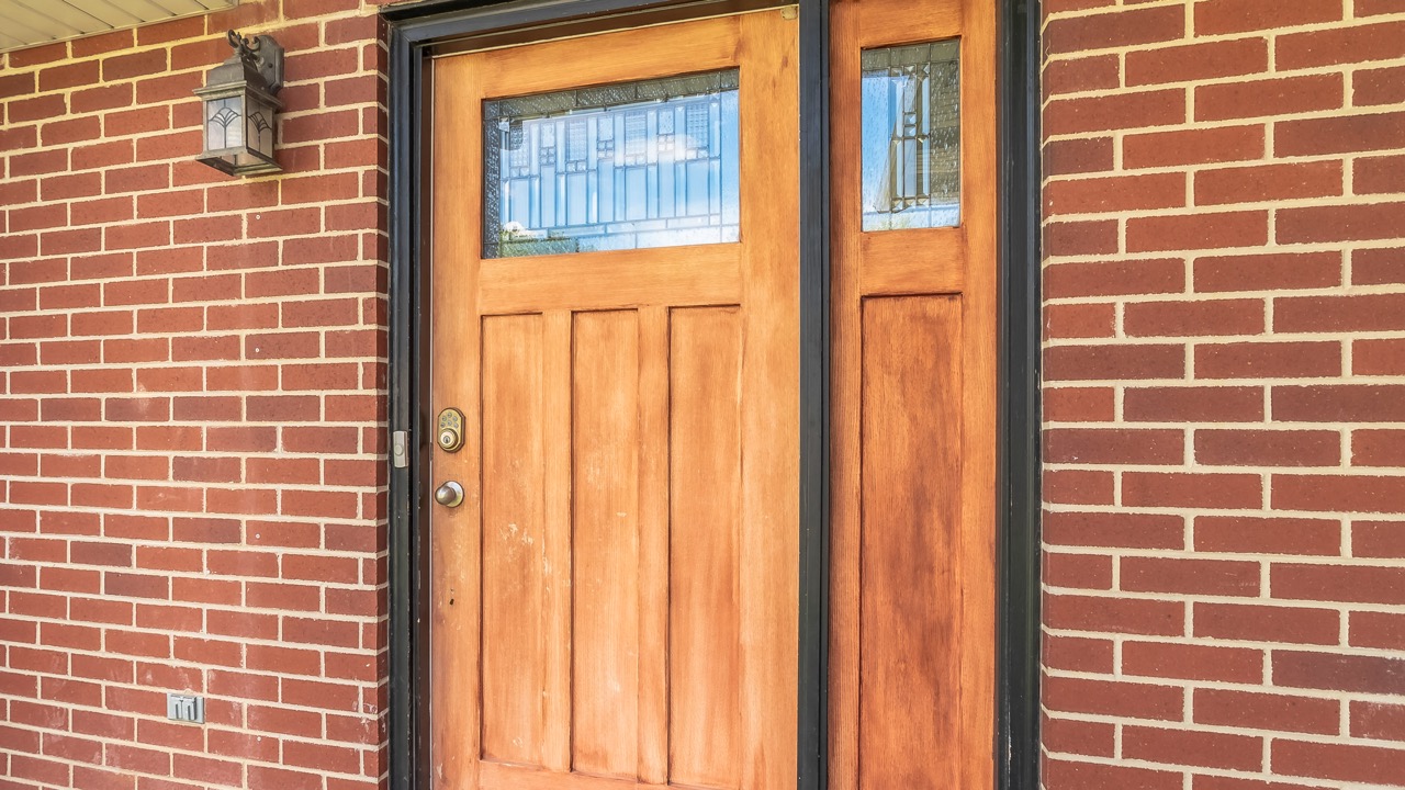 Une porte en bois lumineuse et graphique, parfaite pour une maison au style classique revisité.